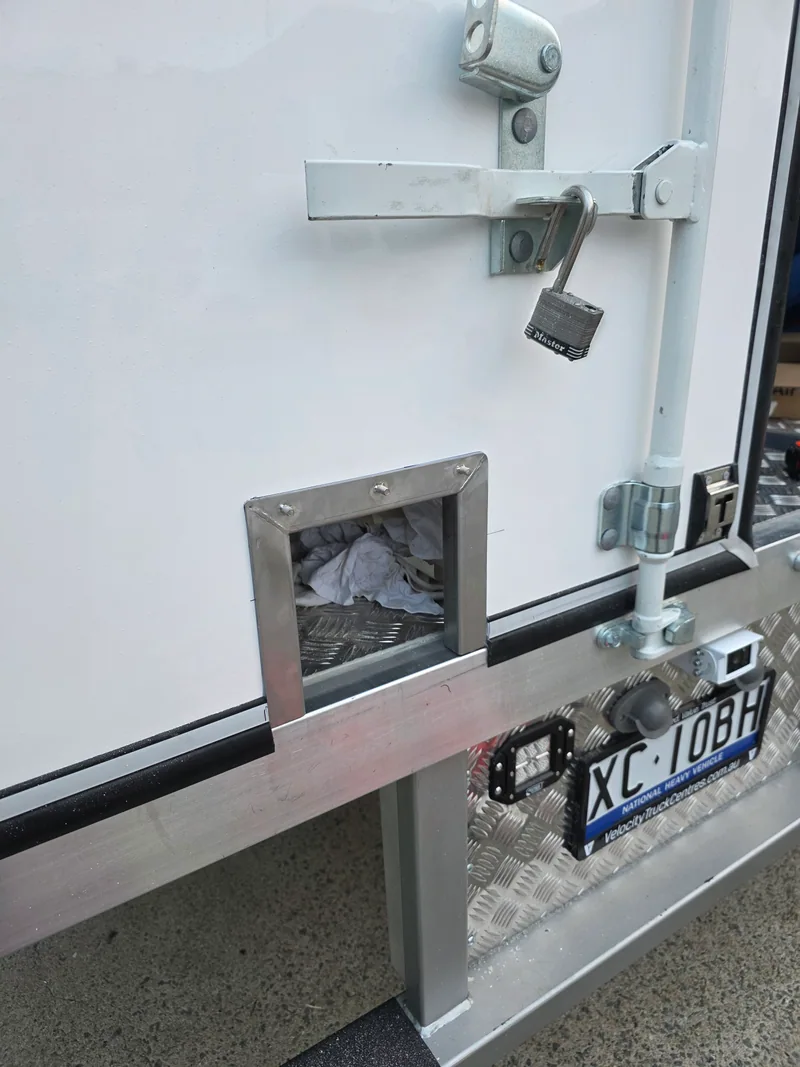 Rear service-door hardware and lower access detail on the specialist truck body